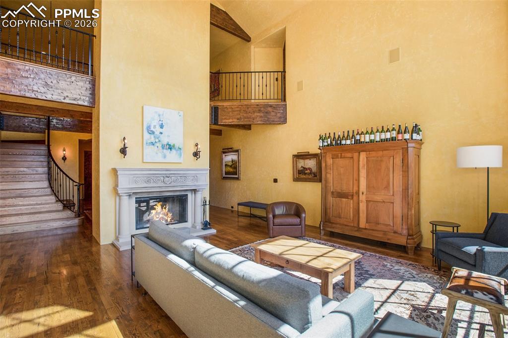 Image 14 of 50: Living room featuring dark hardwood flooring and high vaulted ceiling, and