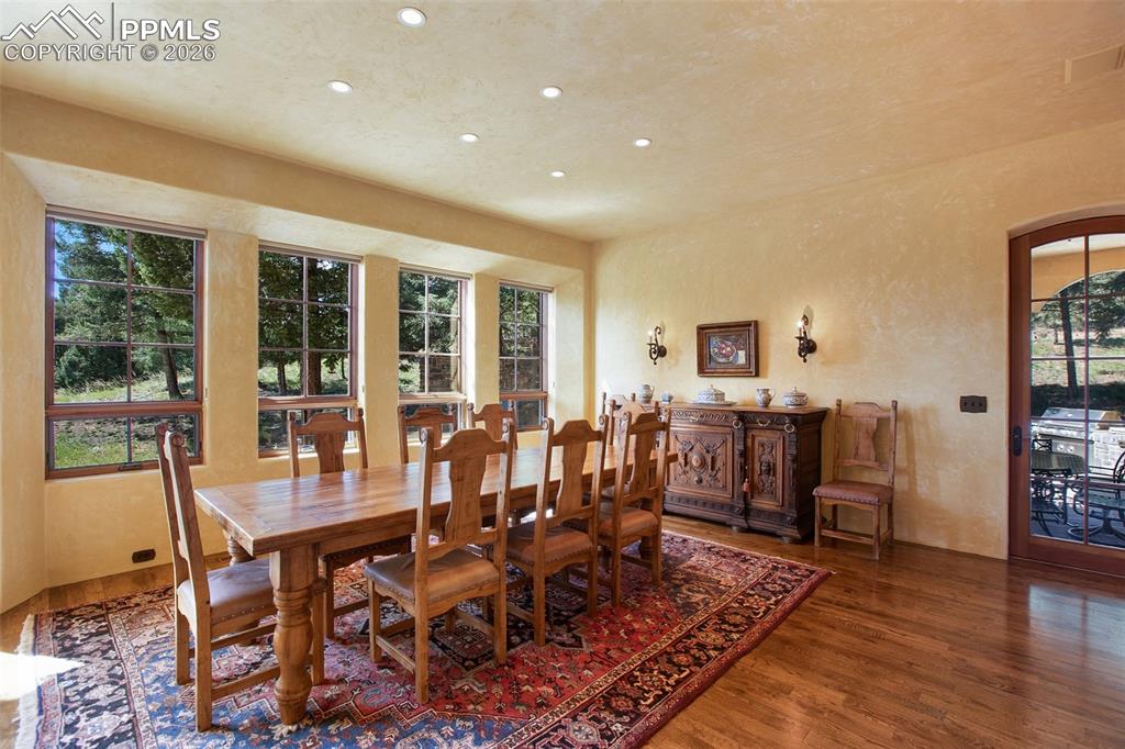 Image 15 of 50: Dining area adjacent to the large gourmet kitchen featuring hardwood floors