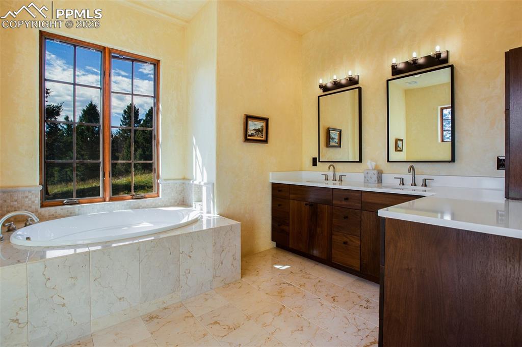 Image 24 of 50: Primary ensuite bathroom featuring double vanity, plenty of natural light,