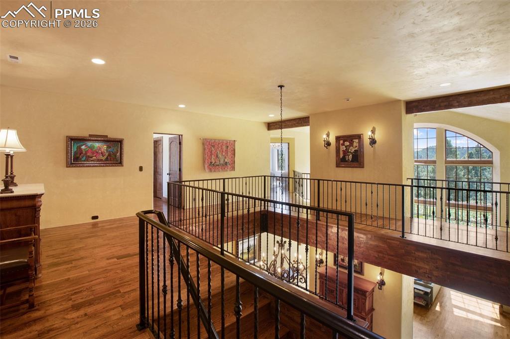 Image 27 of 50: Top of the staircase from the entry and living room with decorative metal r