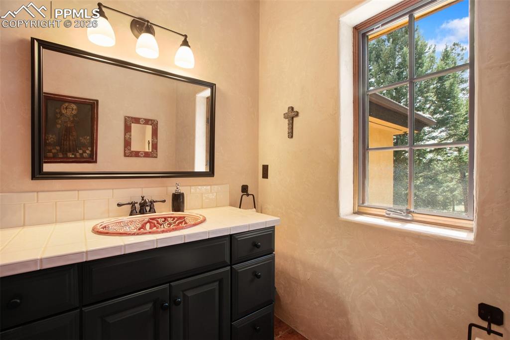 Image 31 of 50: Upper level powder bath with unique lavatory and view of the forest.