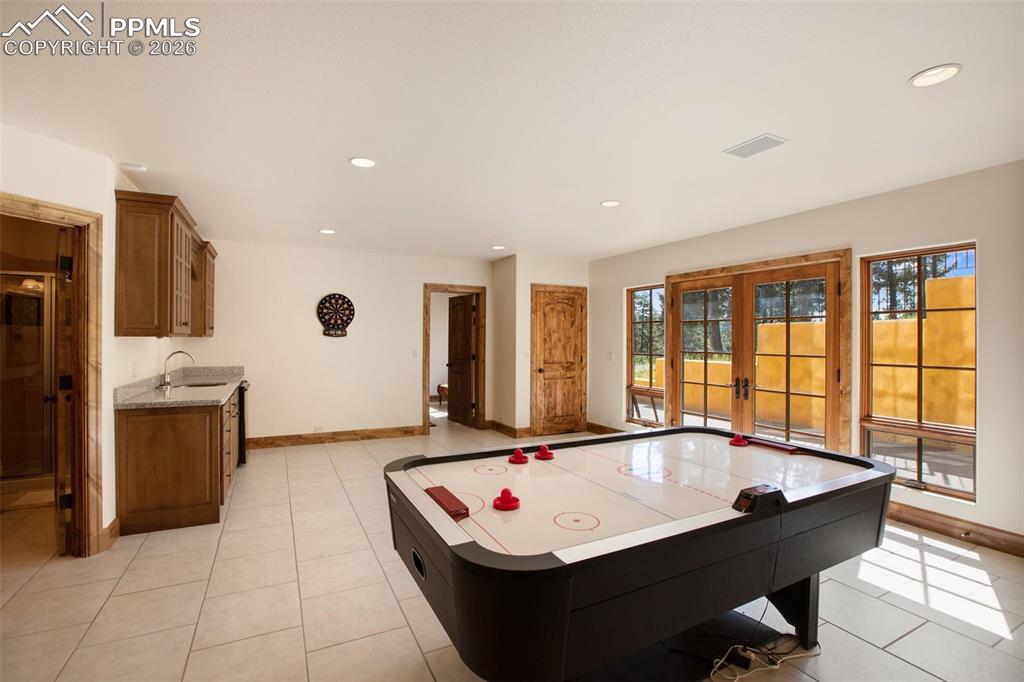 Image 38 of 50: Game room or other type room in the lower level with Wet Bar and walk out t