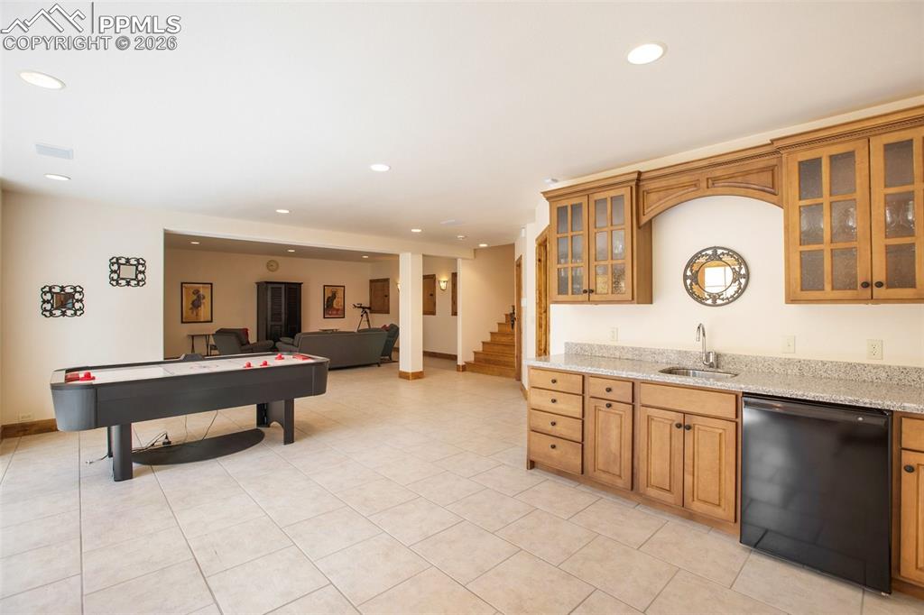 Image 40 of 50: A full view of the Family/Media room, wet bar and game room area in the low