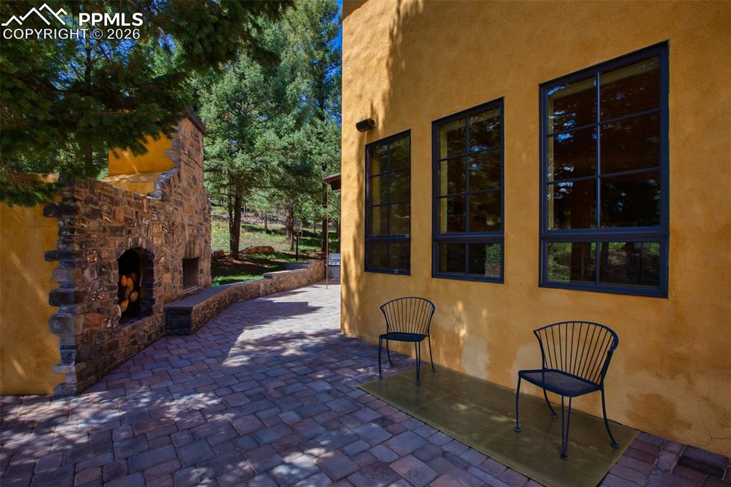 Image 44 of 50: Another view of the patio with fireplace off the main level kitchen and din