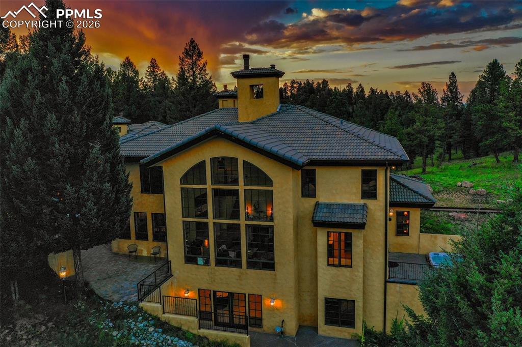 Image 46 of 50: A different view at dusk of the rear of the home with the beautiful remains