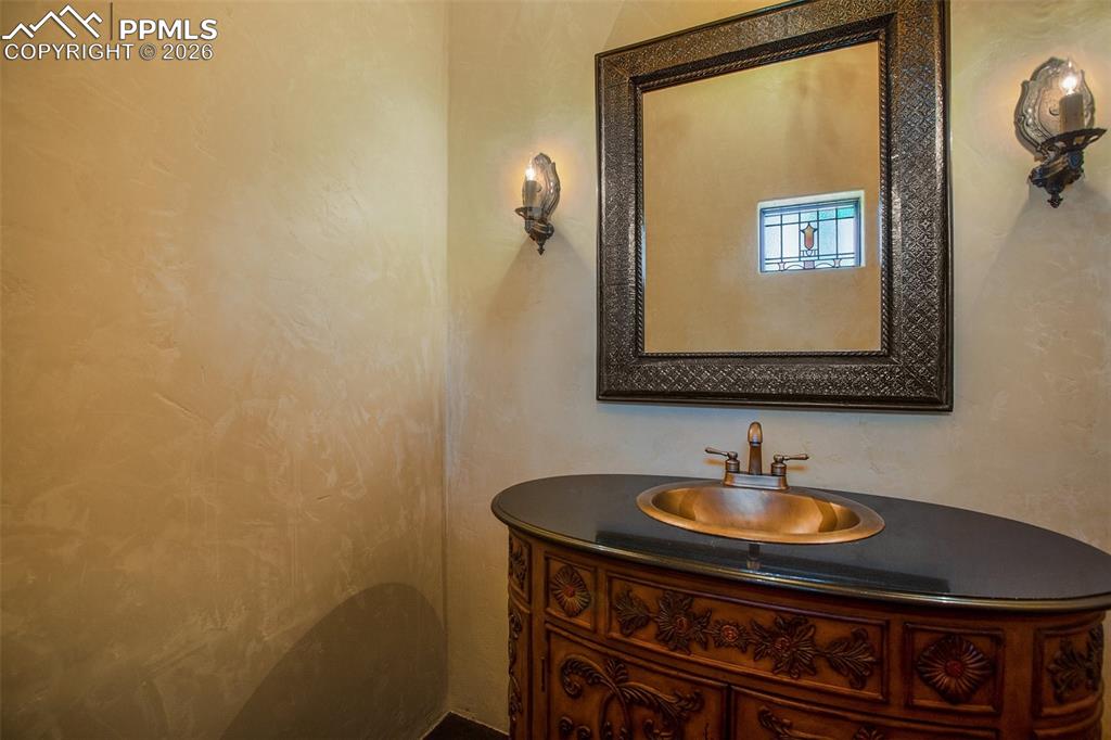 Image 9 of 50: Powder bath with copper sink and beautifully unique sconces.