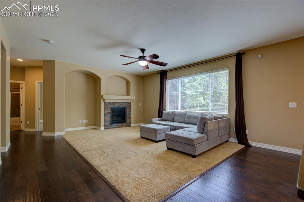 Image 10 of 50: Great room with dark wood flooring with a carpet inlay, gas fireplace and l