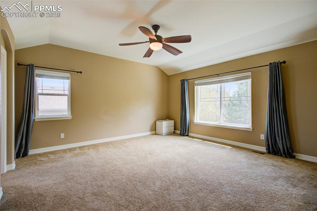 Image 29 of 50:  Large primary bedroom with a ceiling fan and nice windows providing natura