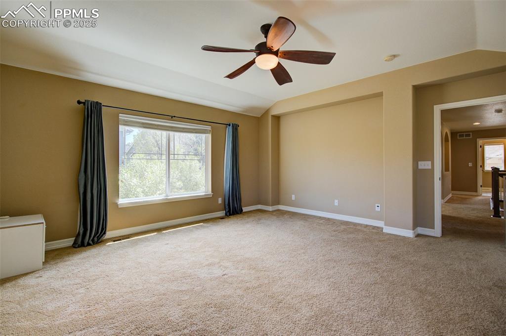 Image 30 of 50:  Large primary bedroom with a ceiling fan and nice windows providing natura
