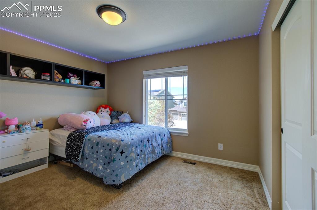 Image 36 of 50: 2nd bedroom with built in shelving