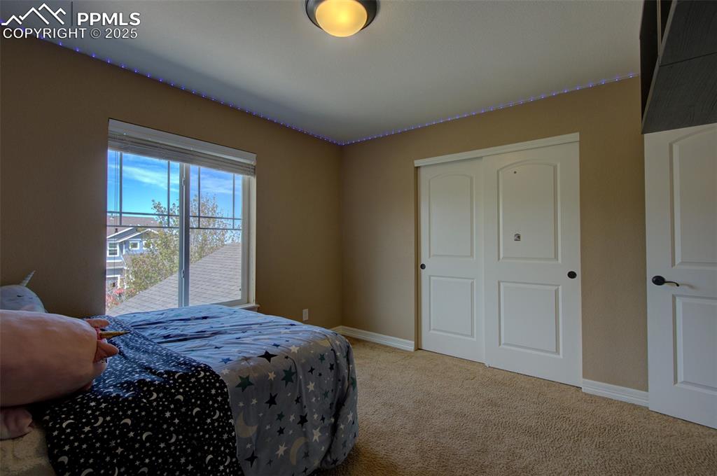 Image 38 of 50: 2nd bedroom with built in shelving and nice sized closet