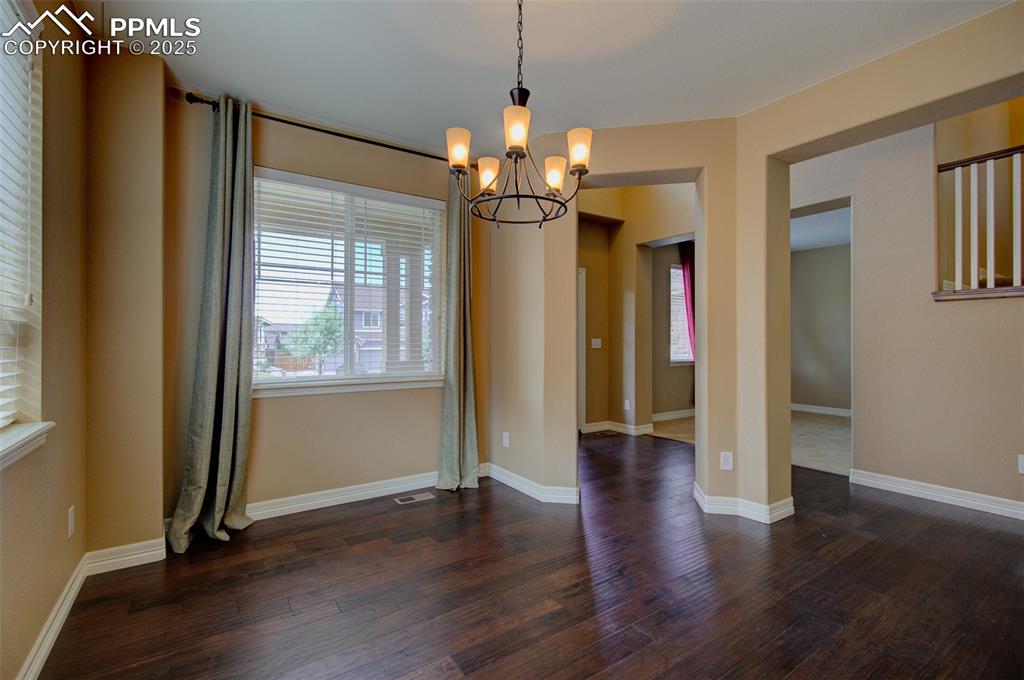 Image 4 of 50: Formal dining area with a chandelier and dark wood-style floors