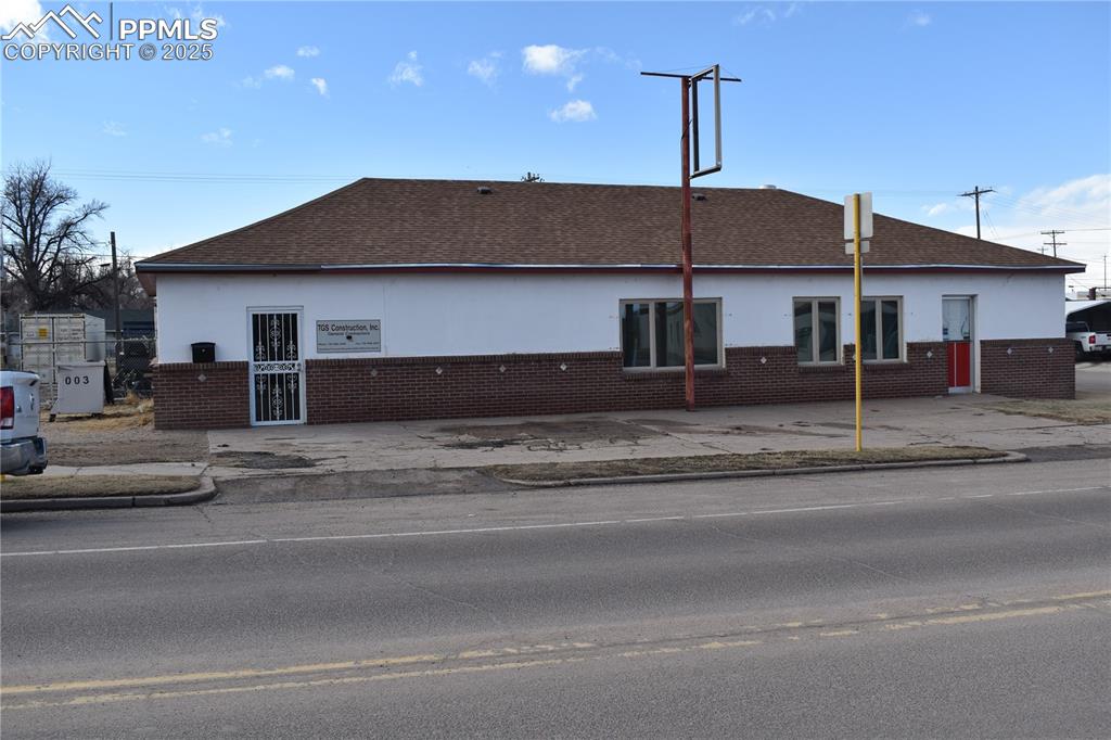 Image 10 of 23: View of front of property with a shingled roof, brick siding, and stucco si