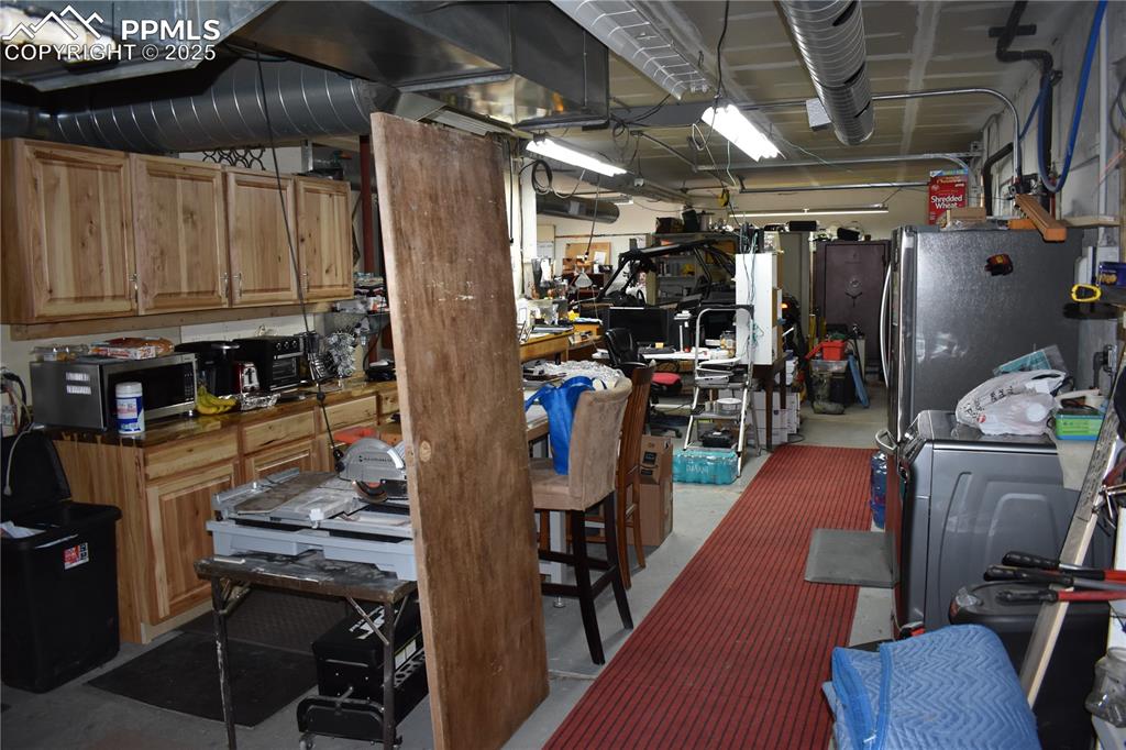 Image 18 of 23: Kitchen with concrete floors, appliances with stainless steel finishes, was