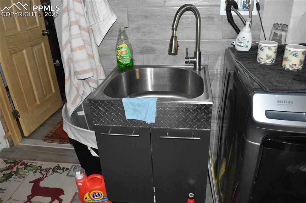 Image 23 of 23: Detailed view of washer / dryer and a sink