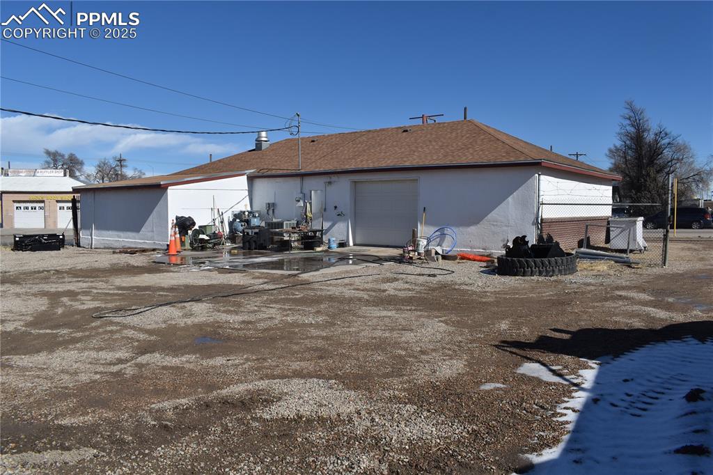 Image 5 of 23: Rear view of property featuring a garage and stucco siding
