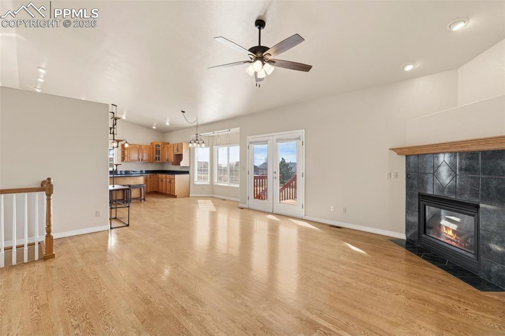 Image 14 of 43: Unfurnished living room with light wood-type flooring, a ceiling fan, a til