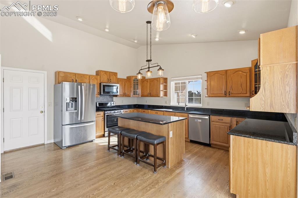 Image 16 of 43: Kitchen with glass insert cabinets, stainless steel appliances, a center is