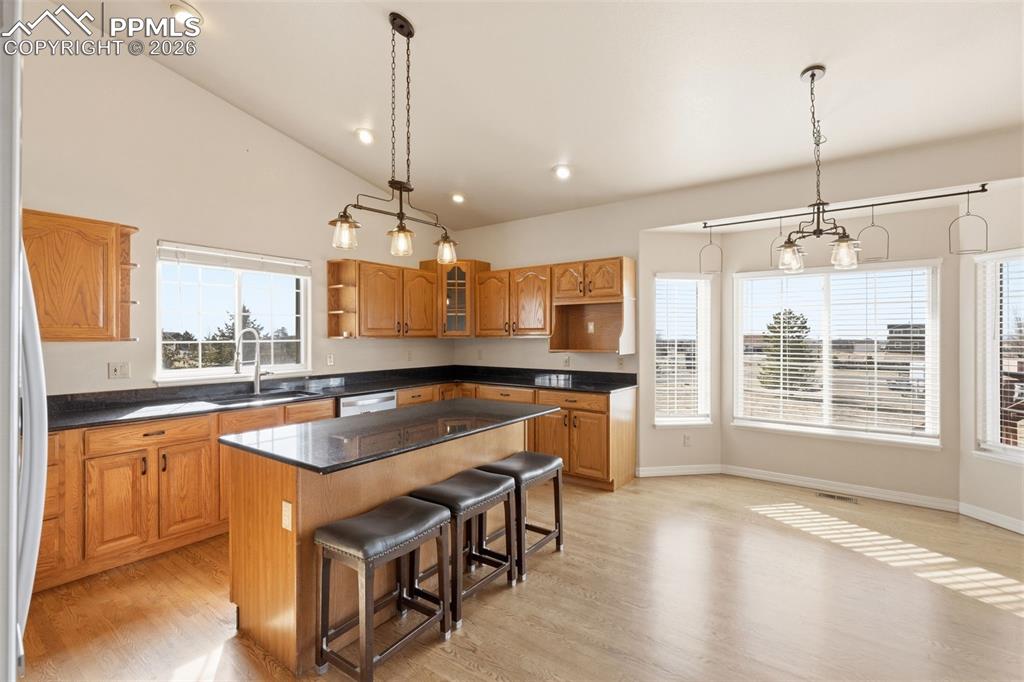 Image 17 of 43: Kitchen with open shelves, a kitchen island, wood finish cabinetry, vaulted