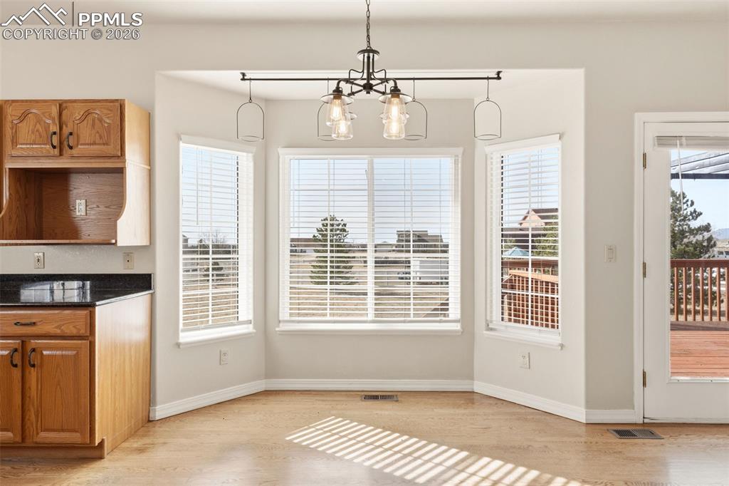 Image 18 of 43: Unfurnished dining area with hanging lights and light wood-style flooring