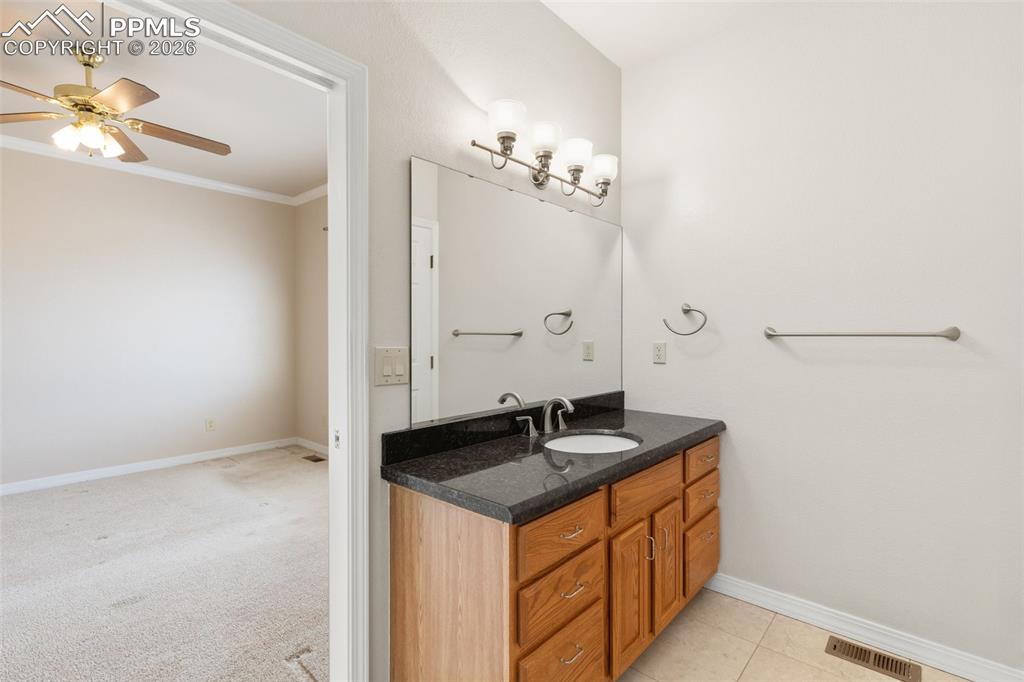 Image 23 of 43: Bathroom with vanity, a ceiling fan, ornamental molding, and light colored 