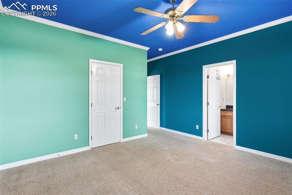 Image 26 of 43: Unfurnished bedroom featuring light colored carpet, ornamental molding, ens