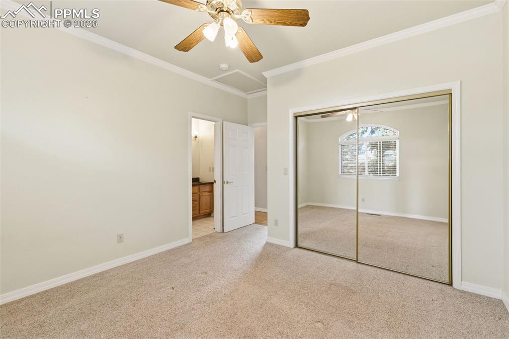 Image 29 of 43: Unfurnished bedroom with crown molding, light carpet, a closet, a ceiling f