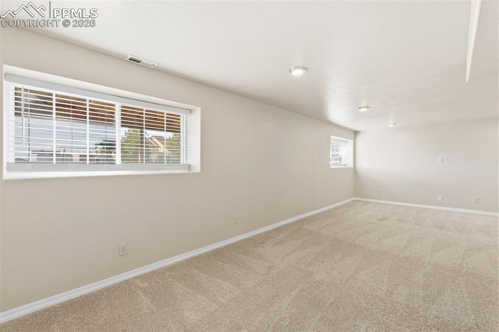 Image 31 of 43: Empty room featuring baseboards and light carpet