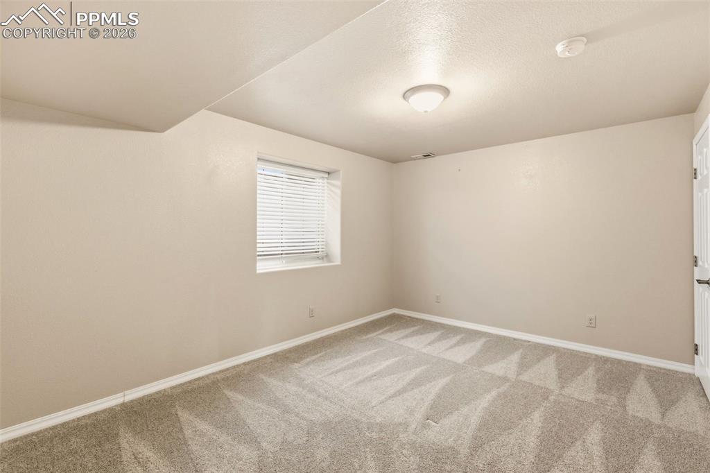 Image 37 of 43: Spare room featuring baseboards and light colored carpet
