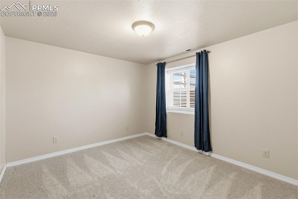 Image 39 of 43: Empty room featuring light colored carpet and a textured ceiling