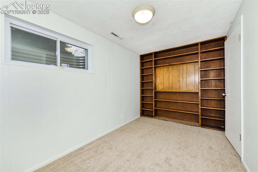 Image 23 of 32: Garden level bedroom with shelves