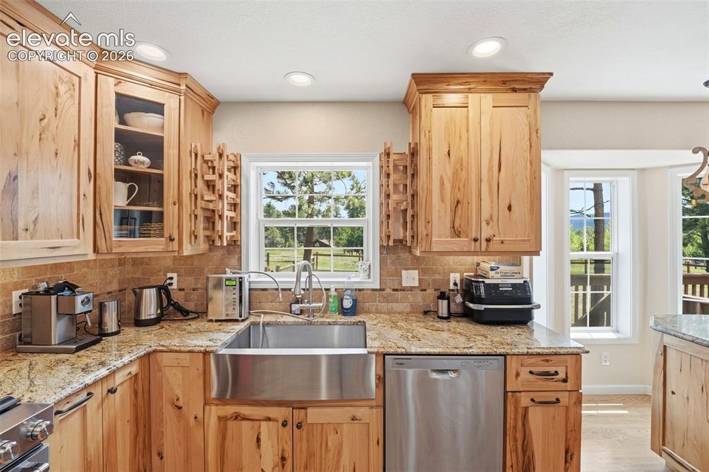 Image 10 of 41: Kitchen featuring natural wood cabinetry, granite countertops, a stainless