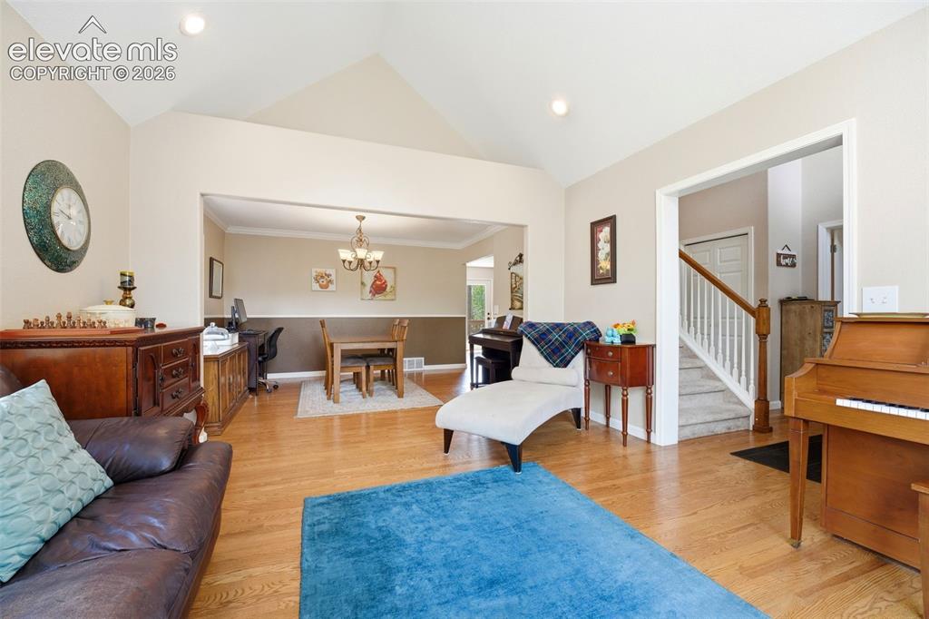 Image 11 of 41: Vaulted ceiling living space featuring wood-finish flooring, recessed light