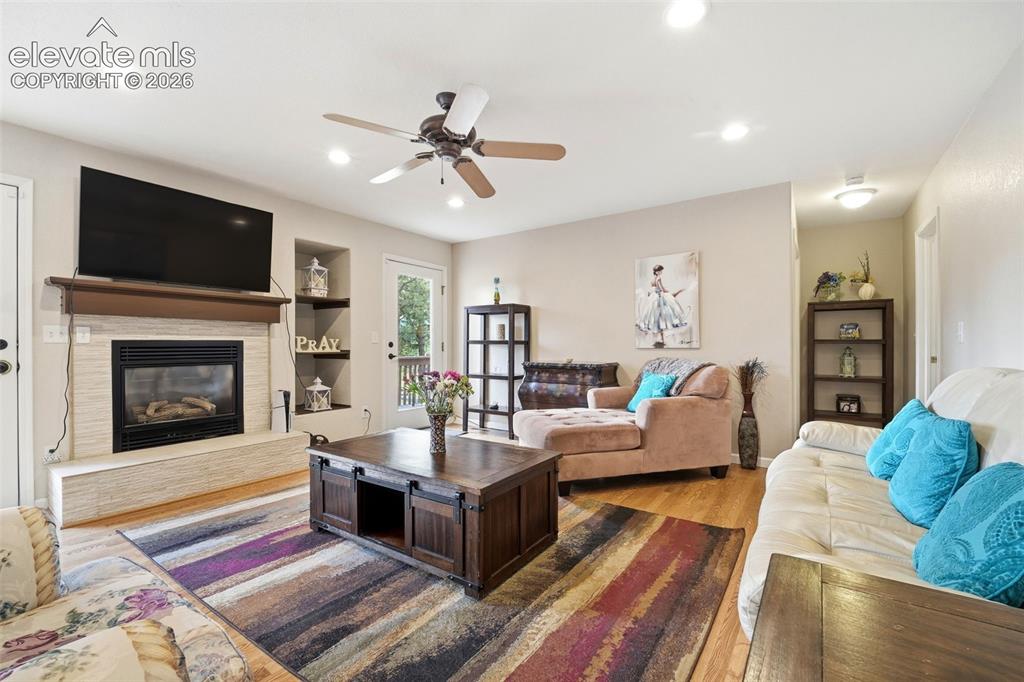 Image 15 of 41: Living room featuring wood-finish flooring, a fireplace with a light-toned