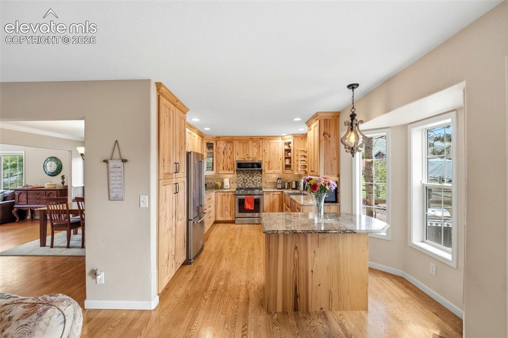 Image 16 of 41: Kitchen featuring natural wood cabinetry, stainless steel appliances, a til