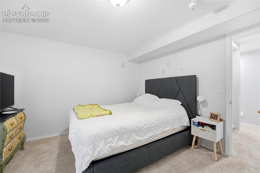 Image 17 of 41: Carpeted room featuring a geometric upholstered headboard, recessed lightin