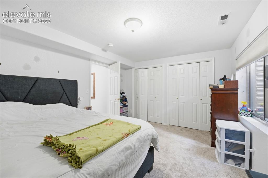 Image 18 of 41: Carpeted room featuring multiple bi-fold closet doors, a window with a deep