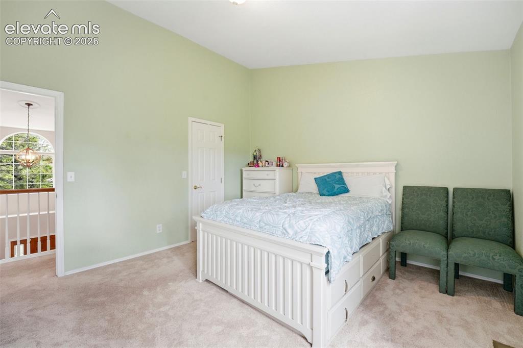 Image 21 of 41: Carpeted room featuring a vaulted ceiling and light green walls