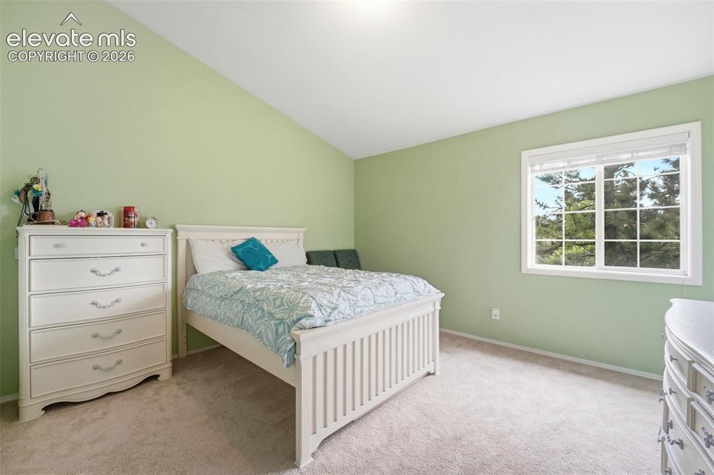 Image 25 of 41: Carpeted room featuring a large window with white blinds, sloped ceiling, a