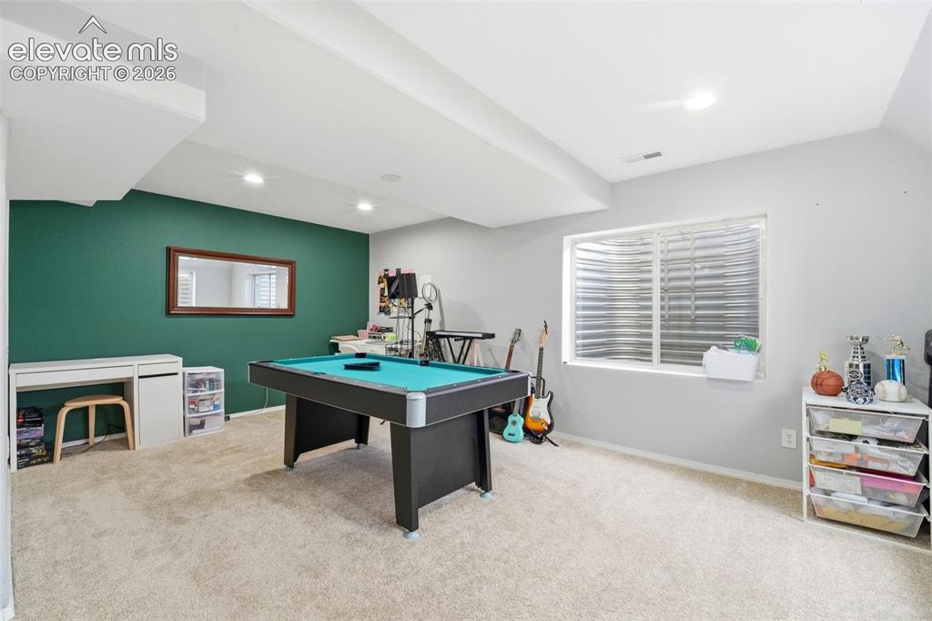 Image 32 of 41: Recreational room featuring a deep green accent wall and a large window