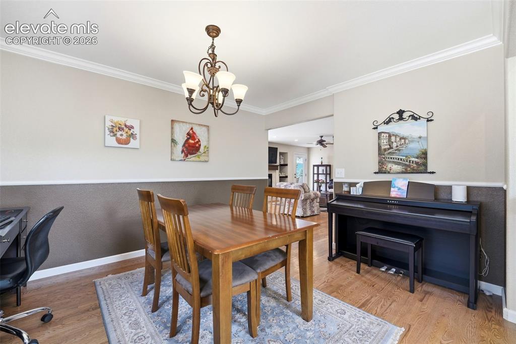 Image 9 of 41: Dining area featuring wood-finish flooring, crown molding, and wainscoting