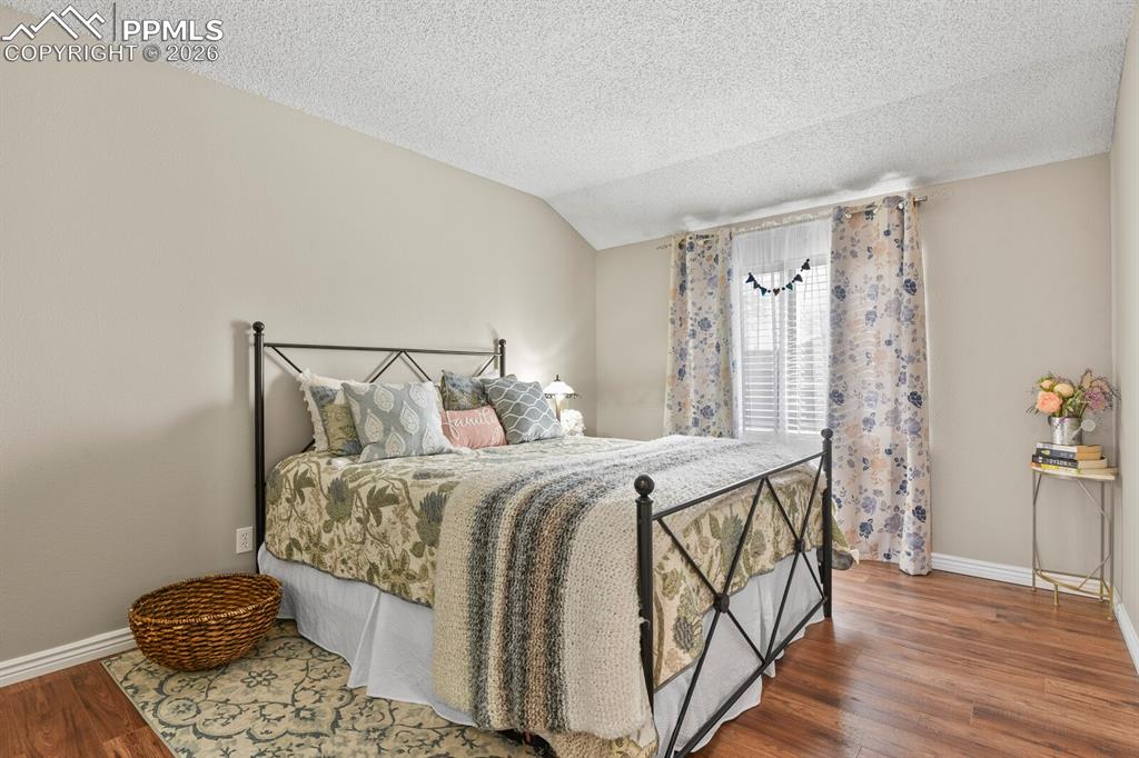 Image 14 of 32: Bedroom with baseboards and dark wood-style floors