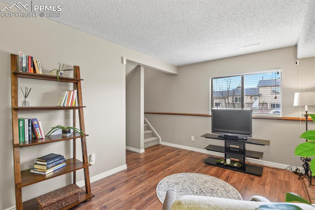 Image 20 of 32: Sitting room featuring a textured ceiling and dark wood-style flooring