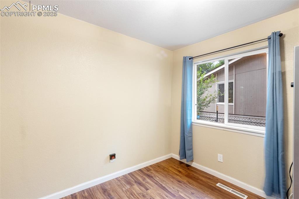 Image 16 of 35: Unfurnished room with baseboards and wood finished floors
