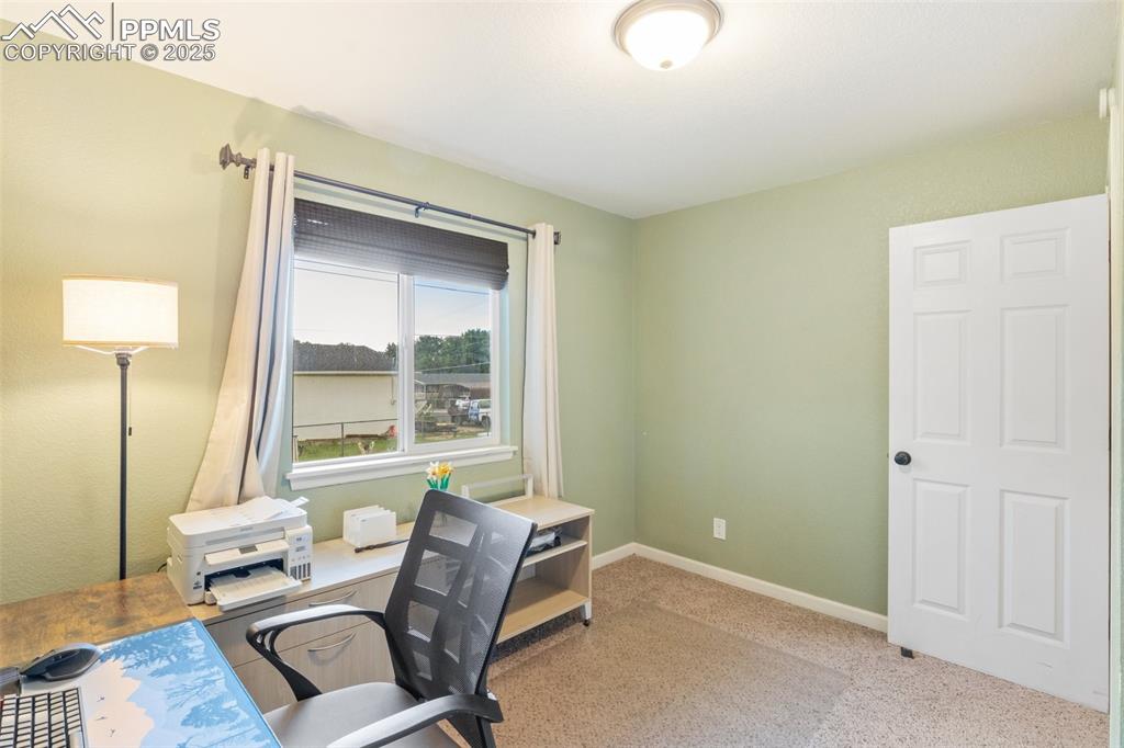 Image 19 of 35: Carpeted home office with baseboards