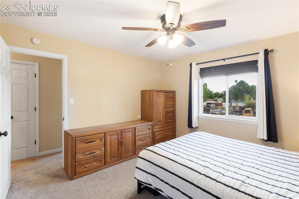 Image 23 of 35: Bedroom with light colored carpet and a ceiling fan