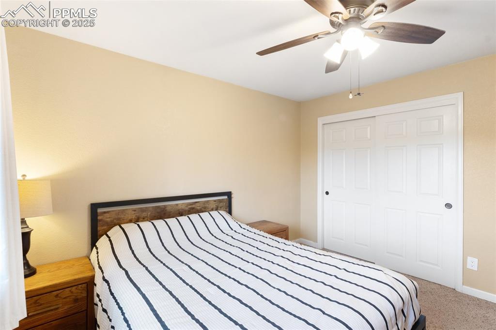 Image 24 of 35: Carpeted bedroom featuring ceiling fan and a closet