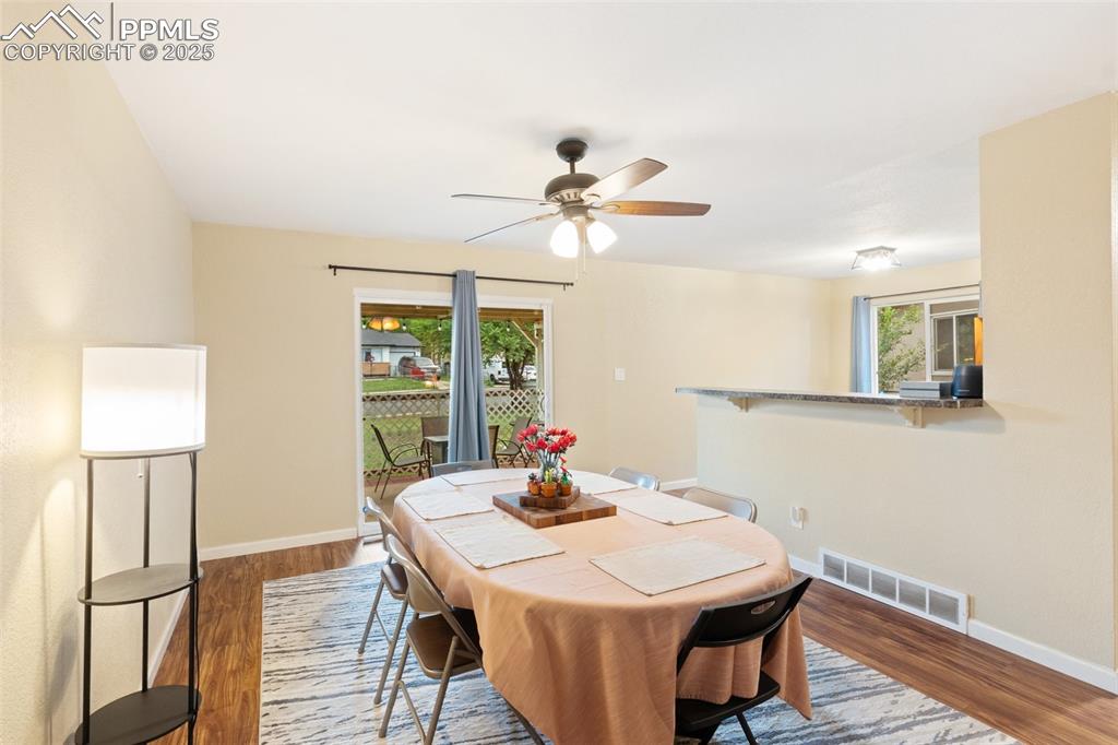 Image 7 of 35: Dining room featuring wood finished floors and a ceiling fan