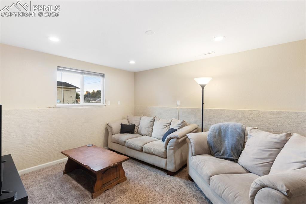 Image 9 of 35: Living area with carpet floors and recessed lighting