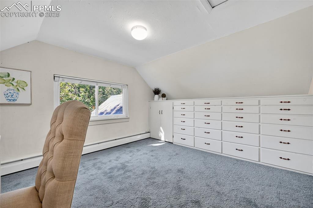 Image 20 of 46: 3rd bedroom Upper Level staged as an office Original built ins and closet
